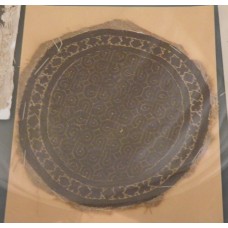 Round inset textile with geometric and floral motives